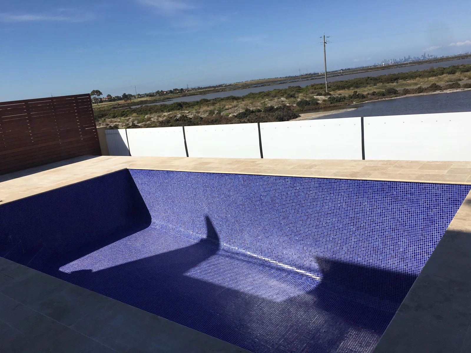 Blue and purple mosaic tiling completed across an outdoor pool interior