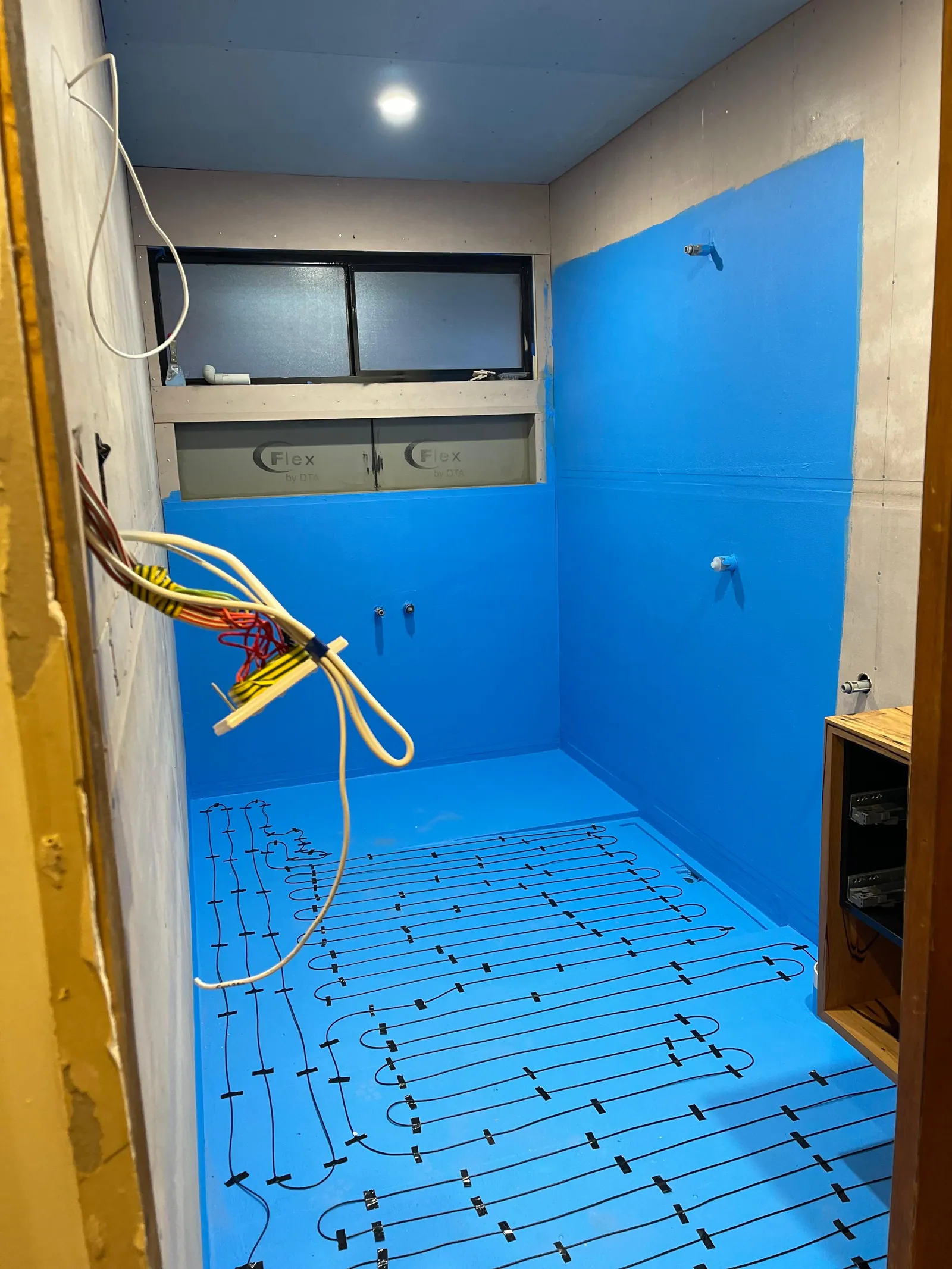 Wet area with waterproofing membrane applied across the floor and walls