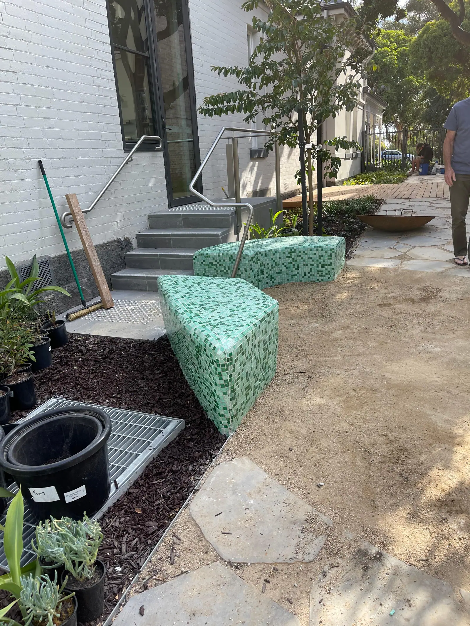 Close view of green mosaic tiling following the curve of the finished form