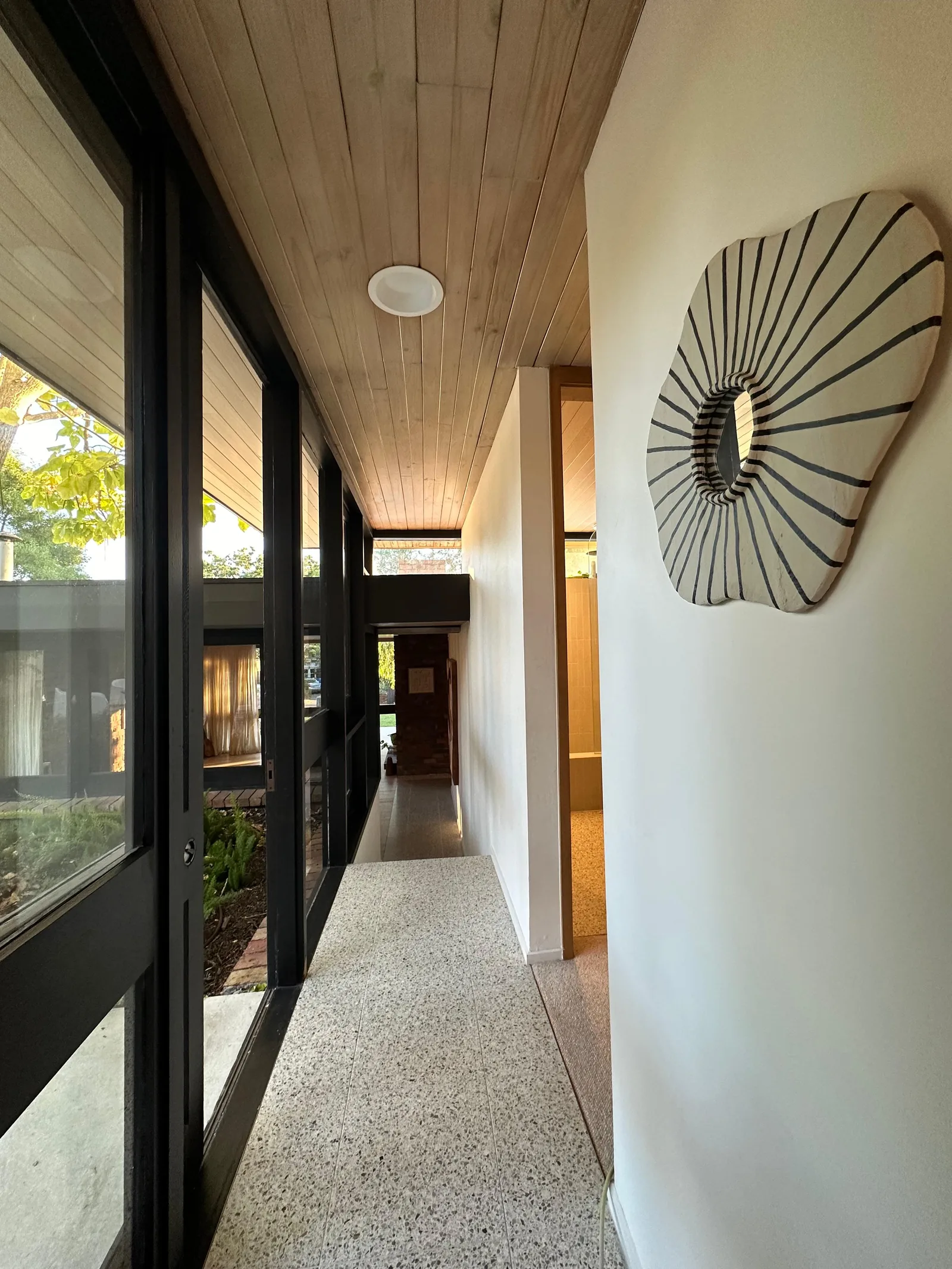 Terrazzo floor tiling continuing through a glazed entry corridor