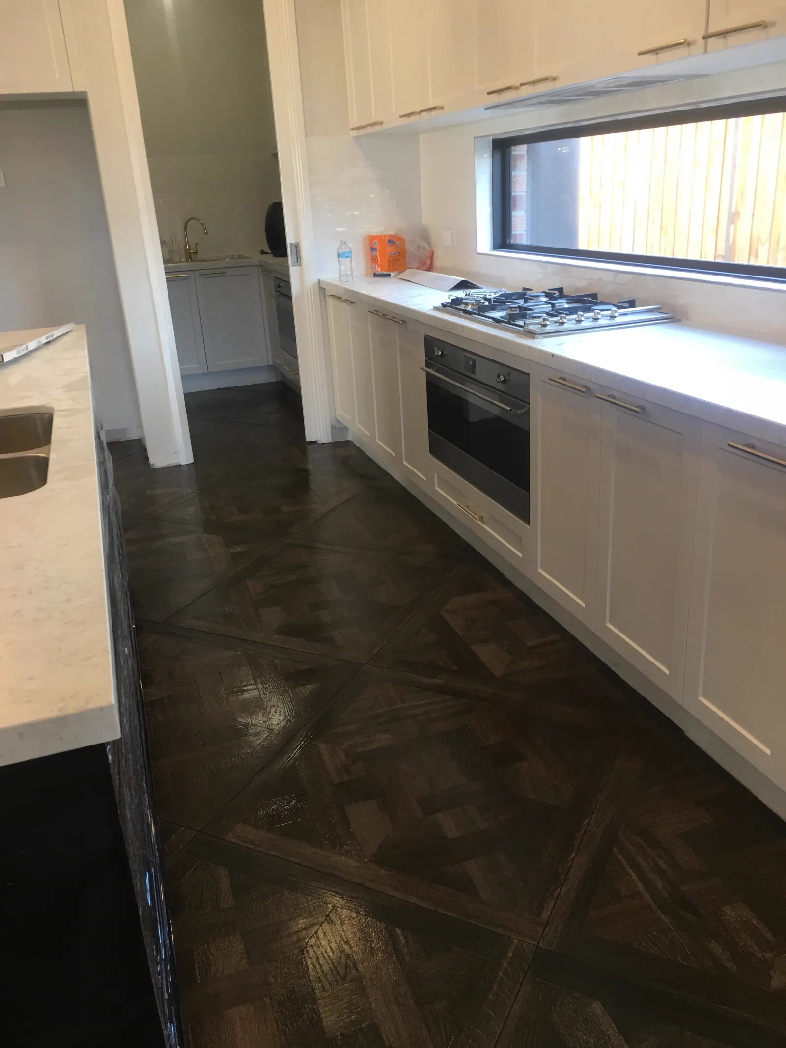 Completed herringbone tiled kitchen floor installed by FA Tiling Group