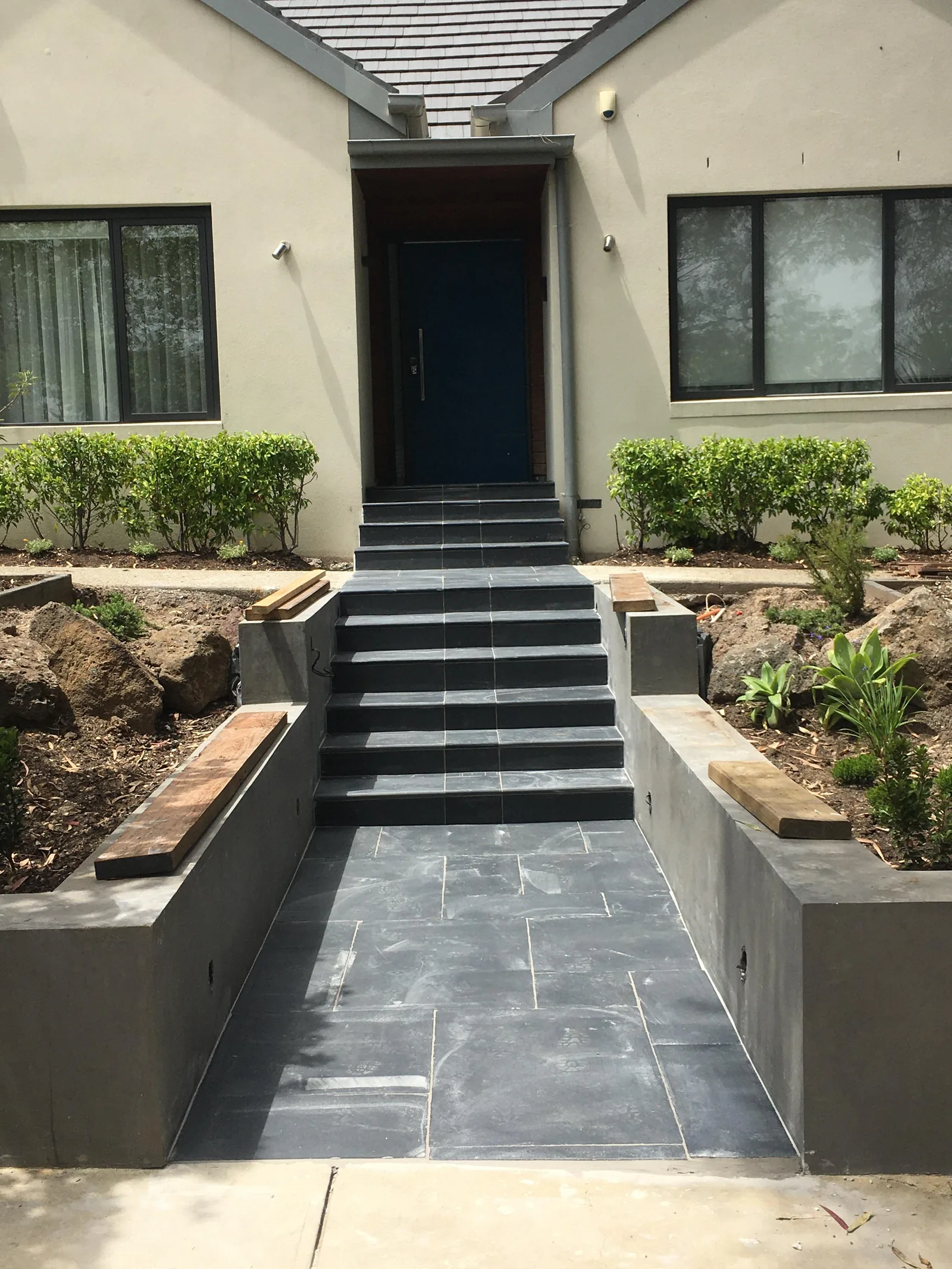 Completed French-pattern stone tiling to an outdoor entry and stairs in Kew