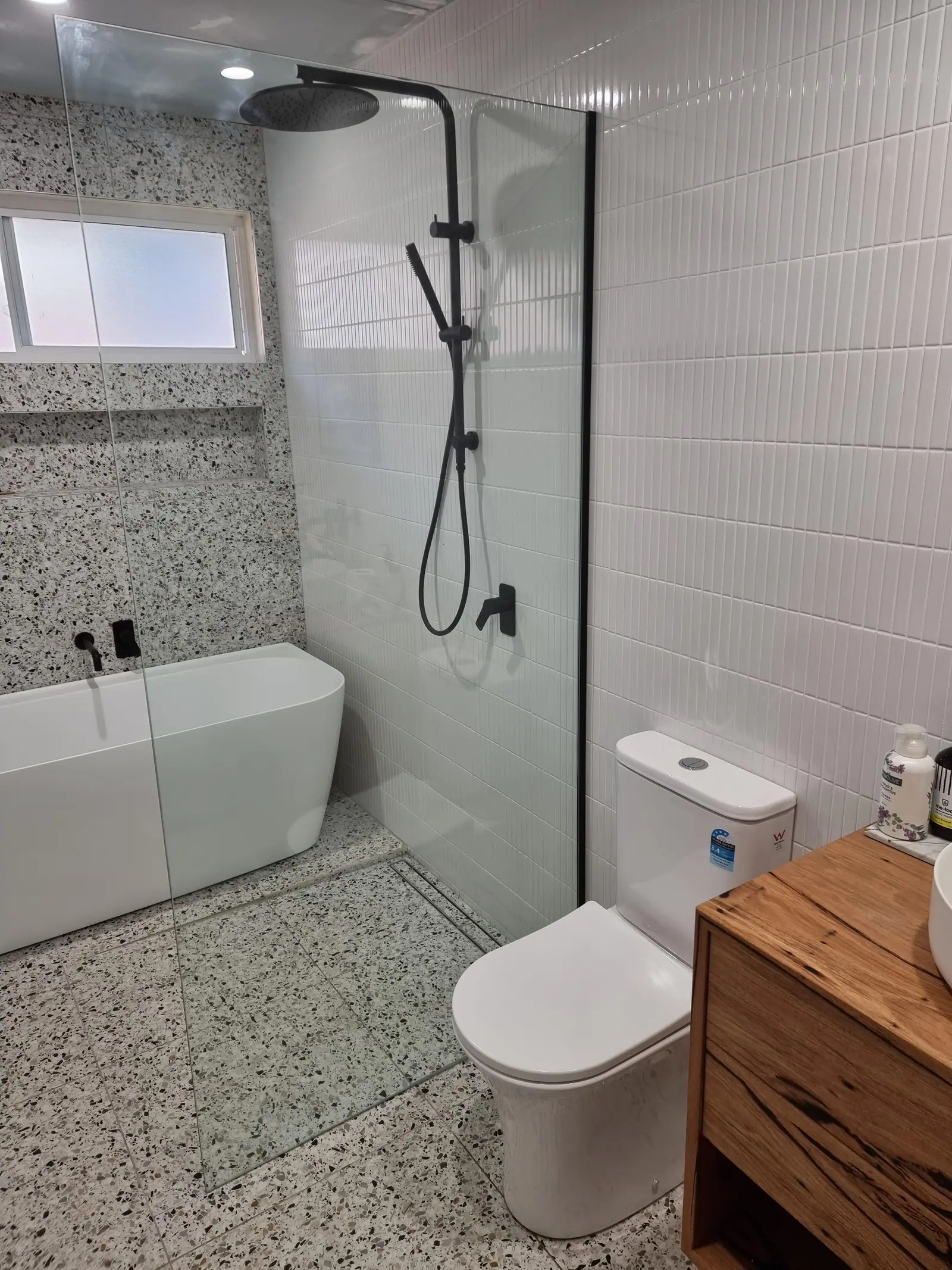 Close view of the completed wet area, showing the tiled shower floor and wall junction