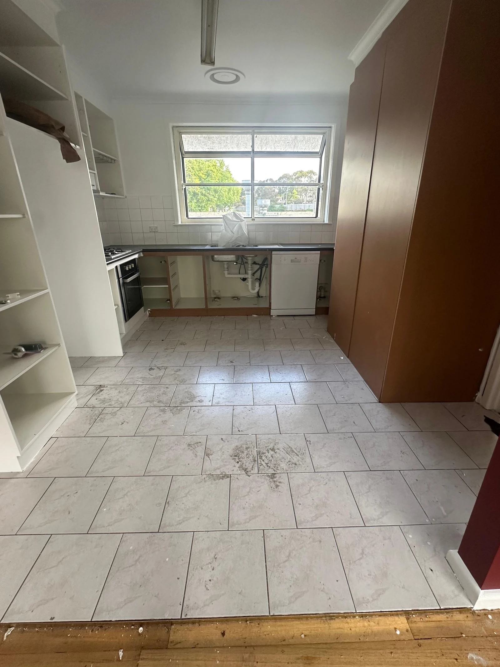Kitchen floor before replacement, with grey rectangular tiles